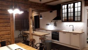 a kitchen with white cabinets and a table and chairs at Sportsmen´s Holiday House in Otepää