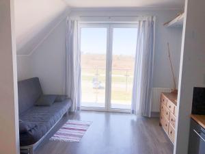 een woonkamer met een bank en een groot raam bij Widok in Jastrzębia Góra