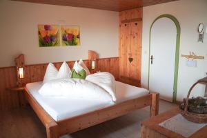 een slaapkamer met een bed met witte lakens en kussens bij Archehof Eislbauer - Deine Ladezone für die Seele! in Sankt Gilgen