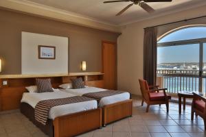 a hotel room with two beds and a balcony at Paradise Bay Resort in Mellieħa