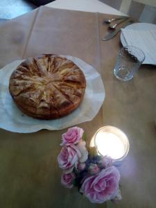 a pizza on a table with a candle and flowers at Hotel Sa Cralla in Villasimius