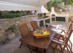 a wooden table with a basket of fruit on a patio at Exceptional Villa in Voula near the sea in Athens