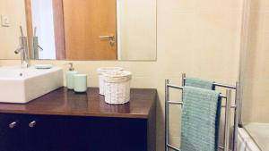 een badkamer met een wastafel en een spiegel bij White Family House in Aveiro
