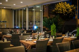 a restaurant with wooden tables and chairs with wine glasses at Hawaii Suite Beach Hotel in Alanya