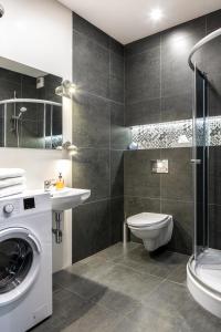 een badkamer met een wastafel en een wasmachine bij Green Garden Residence in Krakau