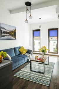 sala de estar con sofá azul y mesa en Green Garden Residence, en Cracovia