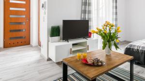 een woonkamer met een tv en een tafel bij Green Garden Residence in Krakau