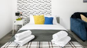 a bedroom with a bed with towels on it at Green Garden Residence in Krakow