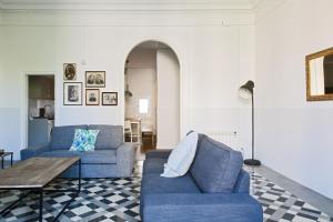 a living room with two blue couches and a table at My Address in Barcelona in Barcelona