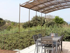 a table and chairs on a deck with a pergola at Superb villa with private pool in Apt