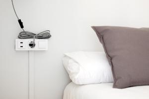 a lightswitch on a wall next to a pillow at My Address in Barcelona in Barcelona