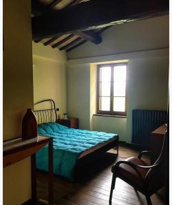Schlafzimmer mit einem Bett, einem Schreibtisch und einem Fenster in der Unterkunft Horti del Baio in Apiro