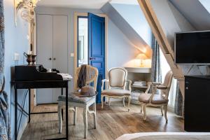 - un salon avec un piano à queue et des chaises dans l'établissement Hôtel des Ducs D'Anjou, à Paris