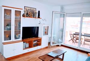 sala de estar con TV y mesa en Apartment Brisa Marina, en Roquetas de Mar