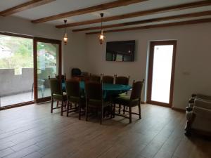 a dining room with a green table and chairs at Casa Dorgo in Lipova