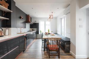 a kitchen with a wooden table and chairs at Courcy Road - 7 bedroom - sleeps up to 22 in London