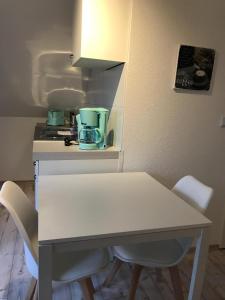 Biały stół i krzesła w kuchni w obiekcie Kleine Möwe w mieście Neßmersiel