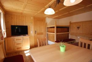 a dining room with a table and a television in a cabin at Ferienhaus "Schneider" in Maria Luggau
