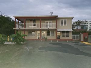 ein Haus mit einem großen Parkplatz davor in der Unterkunft Cozy apartment near the beach (#3) in Fajardo