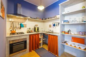 a large kitchen with orange cabinets and counters at Solemar Sicilia - Casa Enza in Santa Flavia