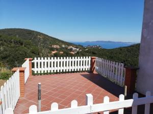 a white fence on a patio with a view of the mountains at Appartamento Cavo in Cavo