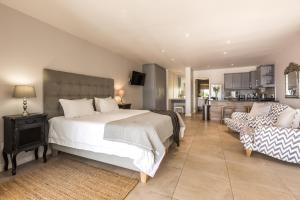 a bedroom with a large bed and a couch at Sunrise Bay Self Catering in Plettenberg Bay