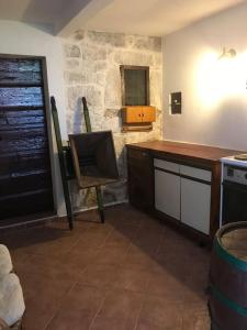 a kitchen with a wooden counter and a stone wall at Dalmatinska kuća Terace in Skradin