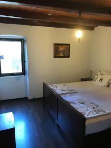 a bedroom with a large bed with a window at Dalmatinska kuća Terace in Skradin