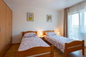 two beds in a room with a window at Apartment Anna with FREE private parking in Pula