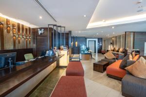 un vestíbulo de un hotel con sofás y un bar en A-One Pattaya Beach Resort, en Pattaya central