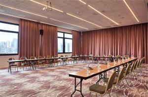 a conference room with long tables and chairs at ibis Styles Sarajevo in Sarajevo +102 photos