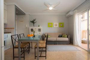 cocina y sala de estar con mesa y sofá en SingularStays Puzol Beach VII, en Puzol