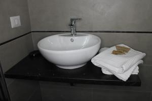 a white sink sitting in a bathroom next to a towel rack at Roma suite Piramide in Rome