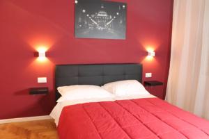 ein rotes Schlafzimmer mit einem Bett mit einer roten Wand in der Unterkunft Roma suite Piramide in Rom