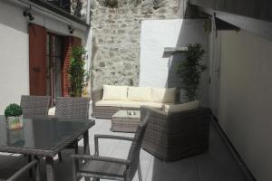a patio with a table and chairs and a couch at Appartement rénové Montreux 2-8 personnes in Montreux