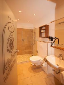 ein Bad mit einem WC, einem Waschbecken und einer Dusche in der Unterkunft Hotel Kleins Wiese in Schmallenberg