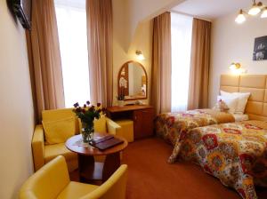 Una habitación de hotel con una cama, una silla y una mesa. en Aparthotel Adler, en Cracovia 40 fotos más