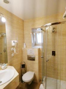 Un baño con ducha, inodoro y lavabo. en Aparthotel Adler, en Cracovia