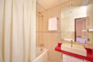 a bathroom with a sink and a shower curtain at MLL Caribbean Bay in El Arenal