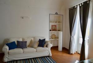 een woonkamer met een witte bank en blauwe kussens bij La mia casa in Biella