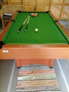a green snooker table with two balls and two cues at Visit Hautakylä in Hautakylä