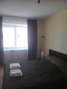 een slaapkamer met een bed met twee handdoeken erop bij Butas Vilniaus alėjoje in Druskininkai