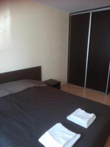 a bedroom with a bed with two towels on it at Butas Vilniaus alėjoje in Druskininkai +4 photos