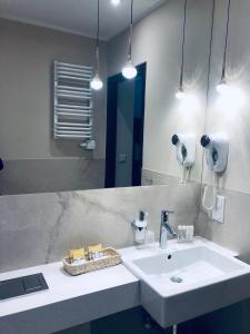 a bathroom with a white sink and a mirror at Hotel Ester in Kraków