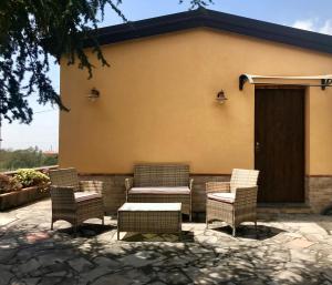 a group of wicker chairs and a table on a patio at Dependance in villa, Etna, natura, relax in Nicolosi