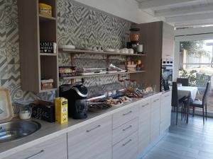 una cucina con armadi bianchi e un bancone con lavandino di Bentus B&B a Villasimius