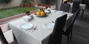 a table with white plates and a bowl of fruit at Bentus B&B in Villasimius