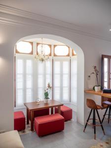 a dining room with a table and red chairs at Es Palauet Brandnew one suite apartment in Ibiza center in Ibiza Town