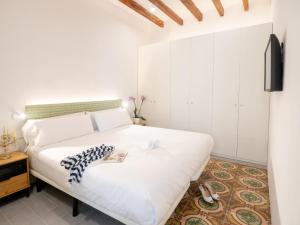 a bedroom with a white bed and a tv at Es Palauet Brandnew one suite apartment in Ibiza center in Ibiza Town