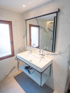 bagno con lavandino e specchio di Es Palauet Brandnew one suite apartment in Ibiza center a Ibiza Città